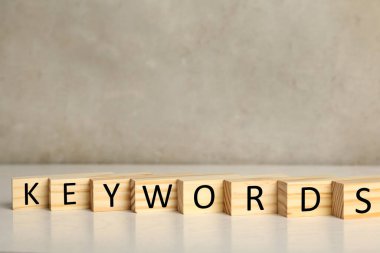 Tahta bloklar ve beyaz masada KEYWORDS yazıyor. Metin için boşluk