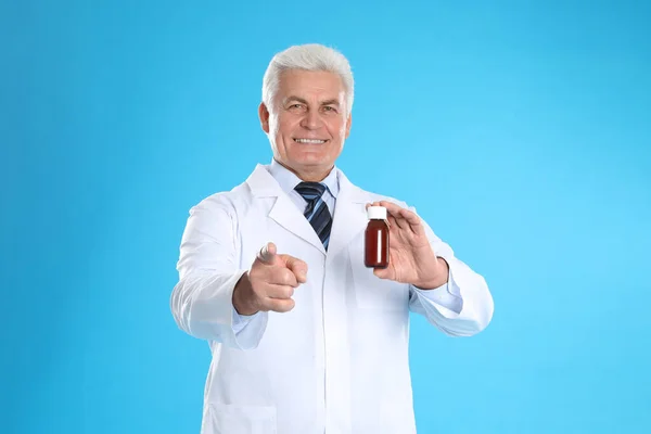Farmacêutico Sénior Com Xarope Sobre Fundo Azul Claro — Fotografia de Stock