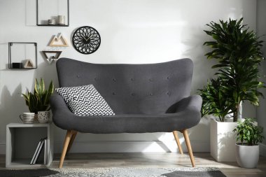 Modern oturma odasındaki şık gri kanepe.