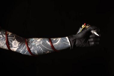 Siyah arkaplanda profesyonel makineli dövme sanatçısı, yakın plan