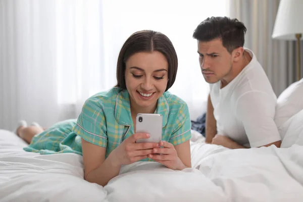 不信任的男人在家里偷看女朋友的智能手机 嫉妒的关系 — 图库照片