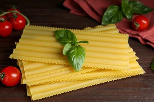 Uncooked Lasagna Sheets Cherry Tomatoes Basil Wooden Table — Stock Photo, Image