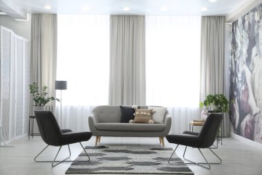 Rahat kanepe ve koltukları olan modern oturma odası.