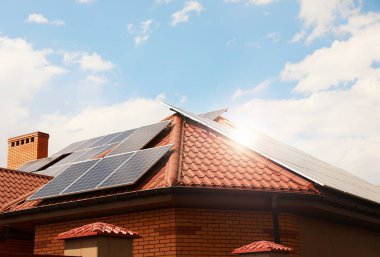 Çatıda kurulu güneş panelleri olan bir bina. Alternatif enerji kaynağı