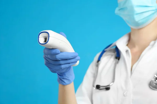 Doctor Holding Non Contact Infrared Thermometer Light Blue Background Focus — Stock Photo, Image