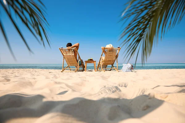 リゾートで日当たりの良いビーチでワインとカップル — ストック写真
