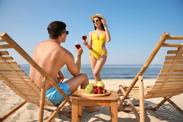 リゾートで日当たりの良いビーチでワインと幸せなカップル — ストック写真