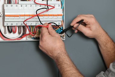 Elektrikçi ve testçi içeride voltajı kontrol ediyor, yakın plan.