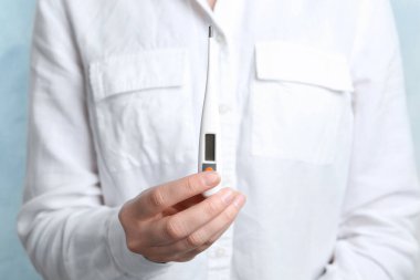Modern dijital termometreyi elinde tutan kadın, yakın çekim görüntüsü