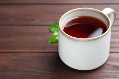 Ahşap masada bir fincan aromatik siyah çay, metin için yer.