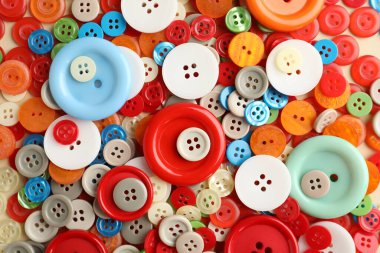 Bej arkaplanda birçok farklı dikiş düğmesi, üst görünüm