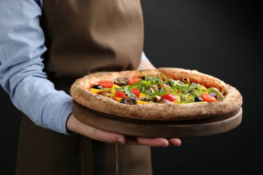 Siyah arka planda lezzetli sebzeli pizza tutan kadın, yakın plan.