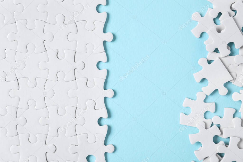 Blank white puzzle pieces on light blue background, flat lay