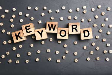 KEYWORD sözcüğüyle ahşap küpler ve koyu gri arka planda boncuklar, düz yatıyordu