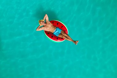 Yüzme havuzunda şişme yüzüklü mutlu bir adam. Yaz tatili