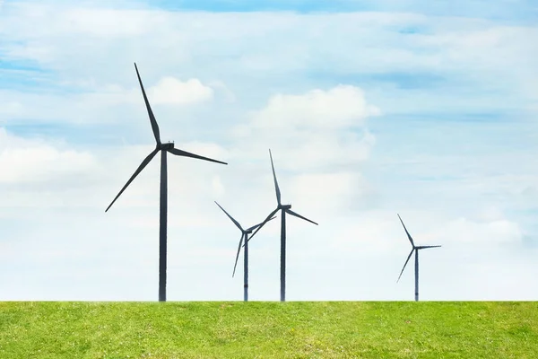 Alternative energy source. Wind turbines in field under cloudy sky