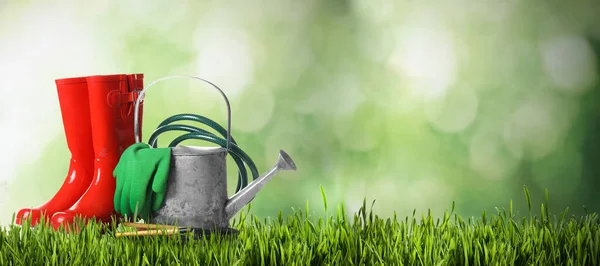 Set of gardening tools on green grass against blurred background, space for text. Banner design