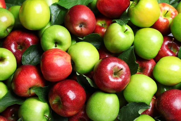 Stapel Smakelijke Rijpe Appels Met Bladeren Als Achtergrond Bovenaanzicht — Stockfoto