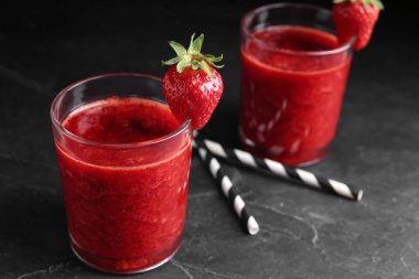 Siyah masada cam içinde lezzetli çilekli smoothie.