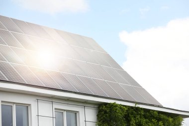 Çatıda kurulu güneş panelleri olan bir bina. Alternatif enerji kaynağı