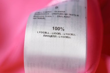 Pembe gömlekte malzeme içeriği olan kıyafet etiketi, yakın çekim görünümü