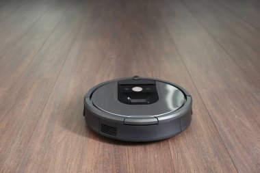 Ahşap zeminde modern robot süpürge.