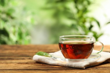 Arka planda bulanık duran bir fincan siyah çay. Metin için boşluk