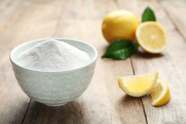 Kabartma tozu ve limon dilimleri ahşap masada.