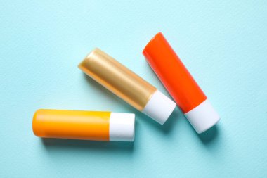 Turkuaz arka planda hijyenik rujlar, düz yatış.