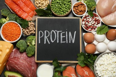 Kelime PROTEIN ve arkaplan olarak farklı ürünler içeren tebeşir tahtası, düz yatıyordu