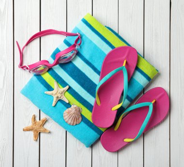 Beyaz ahşap zemin üzerinde plaj nesneleri ile düz kompozisyon yatıyordu