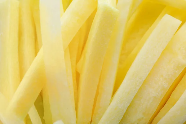 Raw white carrot sticks as background, closeup