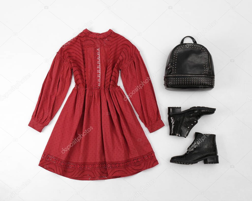 Stylish ankle boots, red dress and backpack on white background, top view