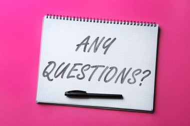 Renk arkaplanı üzerinde herhangi bir soru işareti ve işaret içeren defter, üst görünüm