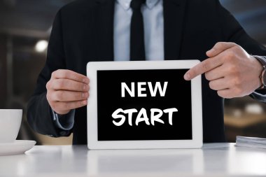 Yeni fırsatlar. Tableti elinde tutan işletme sahibi masadan yeni bir başlangıç, kapatma