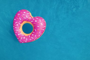 Yüzme havuzunda yüzen şişme yüzüğün üst görüntüsü, mesaj için boşluk. Yaz tatili