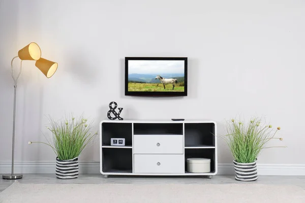 Living room interior with TV set on light wall