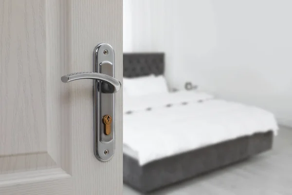 White door open into modern hotel room, closeup