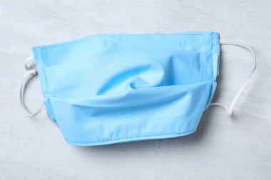 Işıklı arka planda ev yapımı koruyucu maske, üst manzara. Dikiş fikri