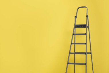 Sarı arka planda metal merdiven. Metin için boşluk