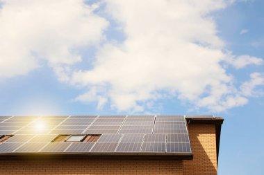 Çatıda kurulu güneş panelleri olan bir bina. Alternatif enerji kaynağı