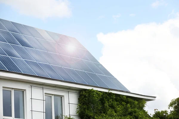 Çatıda kurulu güneş panelleri olan bir bina. Alternatif enerji kaynağı