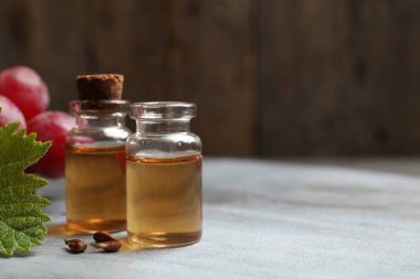 Gri masada doğal üzüm tohumu yağı şişeleri, yazı için yer. Organik kozmetik