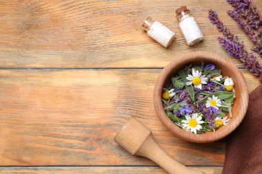 Havan ve farklı şifalı bitkilerle ahşap masa üzerinde düz bileşim, metin için boşluk