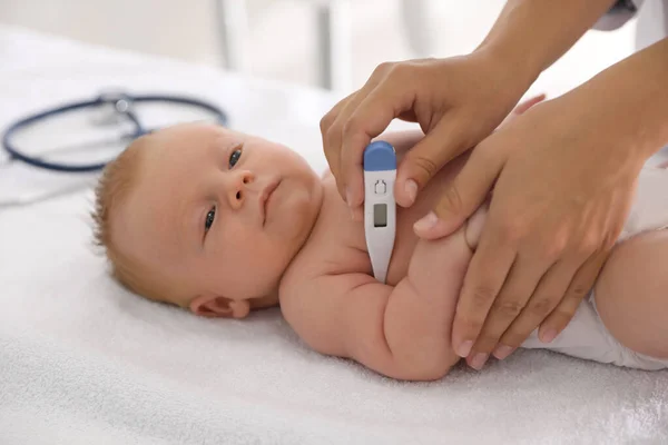 Médico Midiendo Temperatura Del Pequeño Bebé Con Termómetro Digital Interiores —  Fotos de Stock