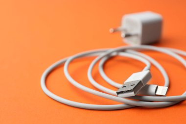 USB kablosu turuncu arka planda, yakın plan. Metin için boşluk