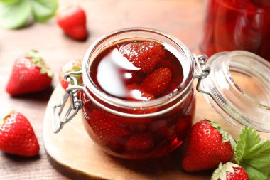 Lezzetli turşulu çilek reçeli ve ahşap masada taze böğürtlen, yakın plan.