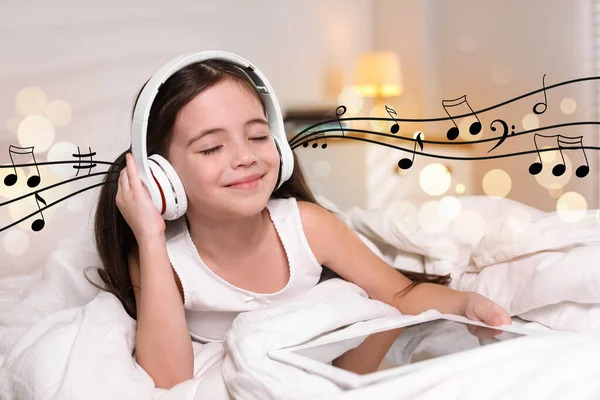 可爱的小女孩 带着平板电脑 通过耳机在家里听音乐 — 图库照片