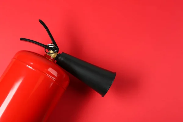 Fire extinguisher on red background, top view. Space for text