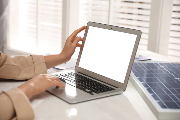 Woman working on project with solar panels at table in office, closeup